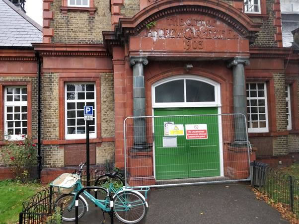 A bicycle parked in front of a brick building  Description automatically generated