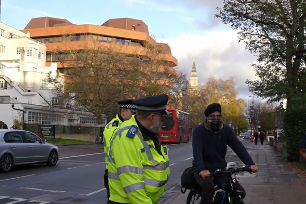 Officers stop an e-bike rider in Ealing