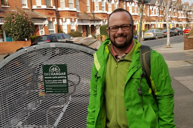 Cllr Gary Malcolm in front of a bike hangar on Valetta Road in Acton