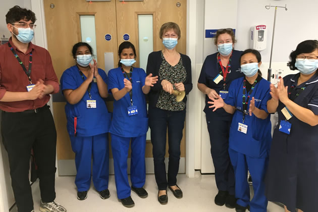 Linda with staff ringing the bell to signify her 'all-clear'